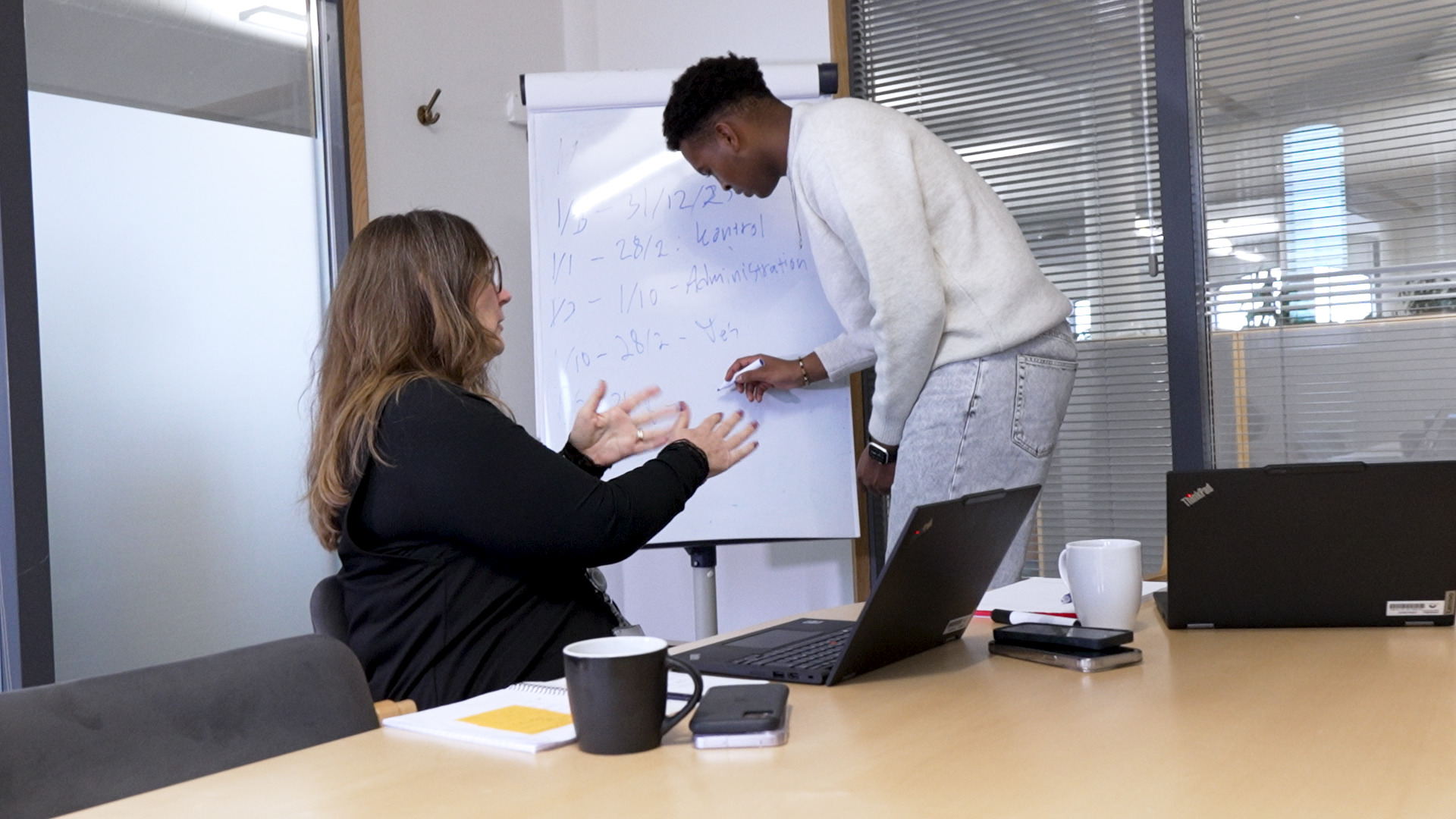 Elev og medarbejder har samtale i et kontorlokale